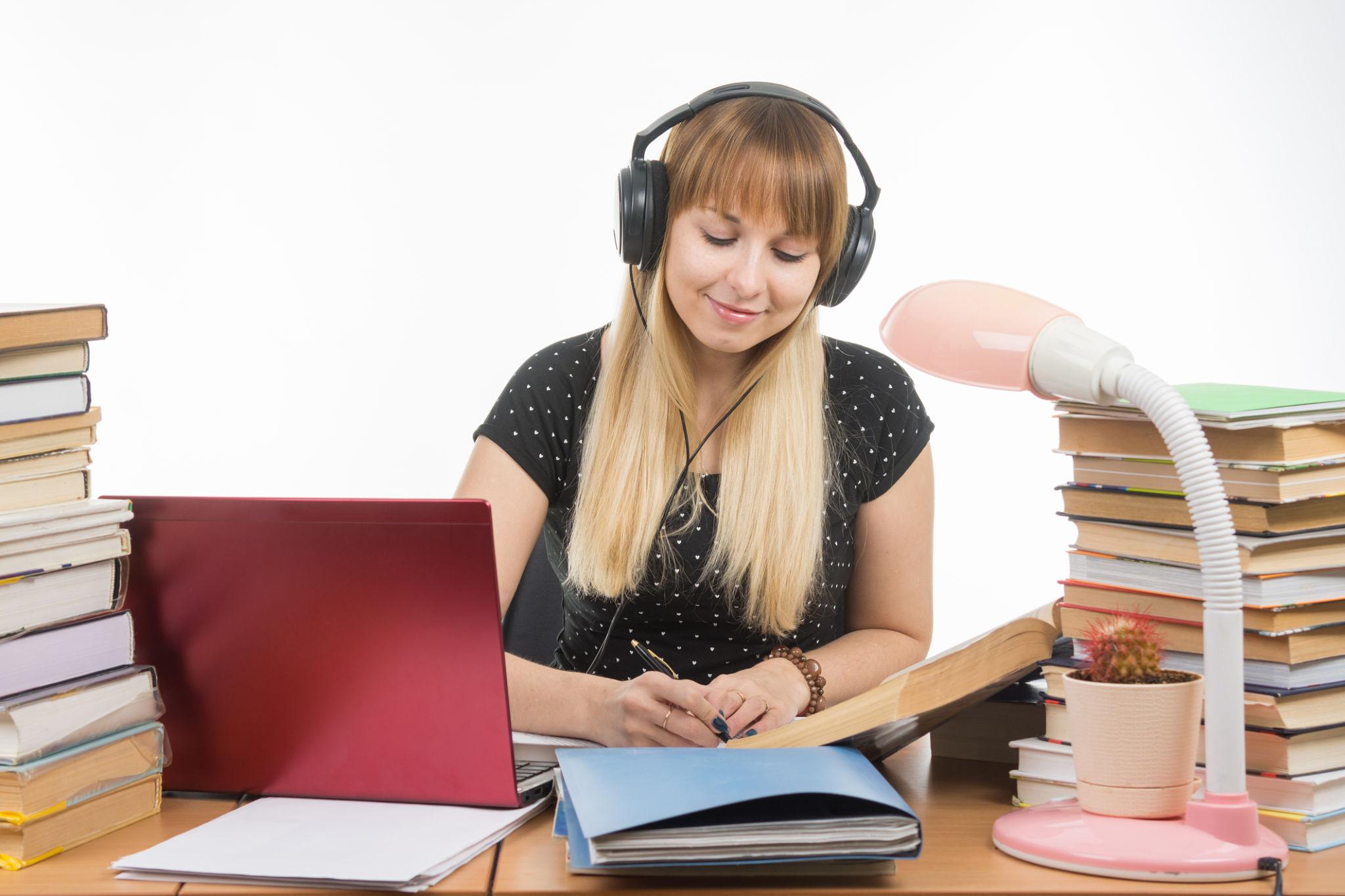 The girl wearing headphones is reading